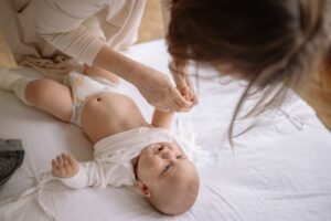 Un parent aide son bébé à enfiler ses vêtements.